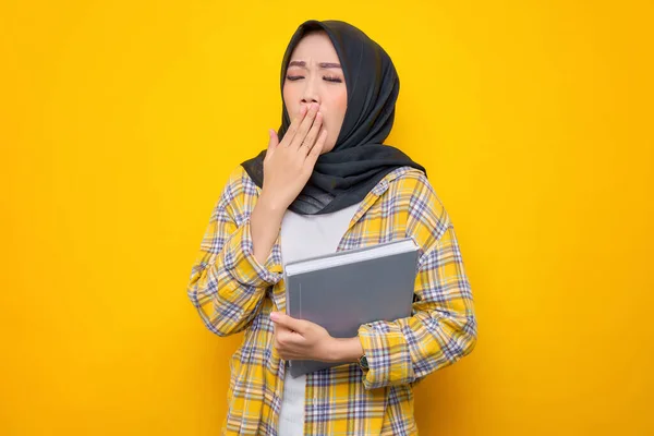 Confused Young Asian Muslim Student Holding Book Feeling Sleepy Isolated — Stock Fotó