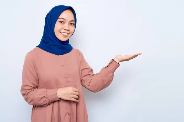 Uśmiechnięta Młoda Azjatycka Muzułmanka Różowej Koszuli Pokazująca Przestrzeń Dłoni Odizolowaną — Zdjęcie stockowe