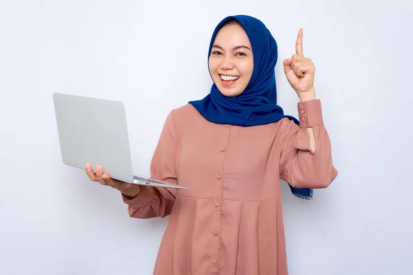 Uśmiechnięta Młoda Azjatycka Muzułmanka Różowej Koszuli Trzymająca Laptopa Wskazująca Palcem — Zdjęcie stockowe