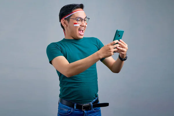Cheerful Young Asian Man Casual Shirt Looking Mobile Phone Screen — Stockfoto
