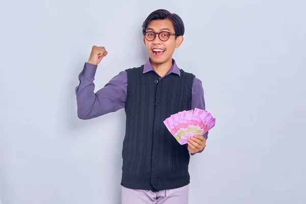Heyecanlı Genç Asyalı Adamı Rupiah Banknotlarında Nakit Para Tutuyor Beyaz — Stok fotoğraf