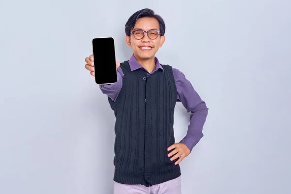 カジュアルなシャツを着た若いアジア人男性を笑顔と白の背景に隔離されたモバイルアプリをお勧めします 空白の画面の携帯電話を示すベスト 人々のライフスタイルコンセプト — ストック写真