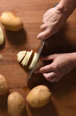  Bir aşçının yüksek açılı bir manzarası var. Ormanda patates keserken.