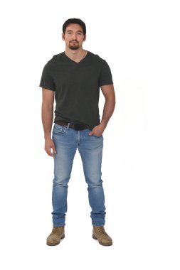 Kot pantolonlu, el cebinde beyaz arka planda kameraya bakan bir adamın tam potpurisi.