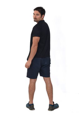 Spor şort giyen bir adamın beyaz arka planda izole edilmiş kameraya baktığı arka plan.