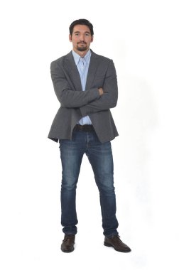 Ceketli ve kolları beyaz arka planda çapraz kot giyen bir adamın yan görünüşü.