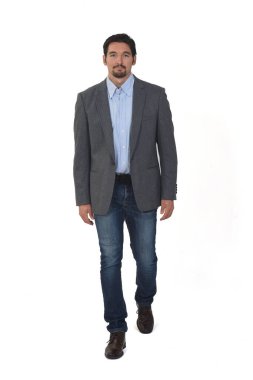 Beyaz arka planda yürüyen spor ceketli bir adamın ön görüntüsü