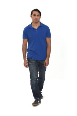 Beyaz arka planda dövmeleri olan sıradan giyinmiş ciddi bir adam.