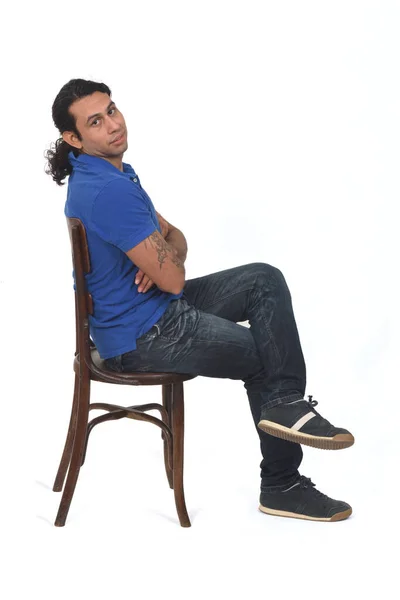 白い背景にカメラと腕と足を見た椅子に座るポニーテールとカジュアルな服を着た男の横顔 — ストック写真