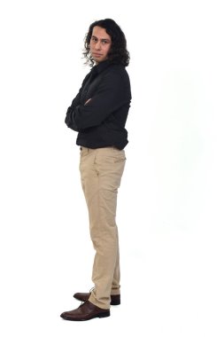 Beyaz arka planda kamera ve kollara bakan uzun saçlı bir adamın yan görüntüsü.