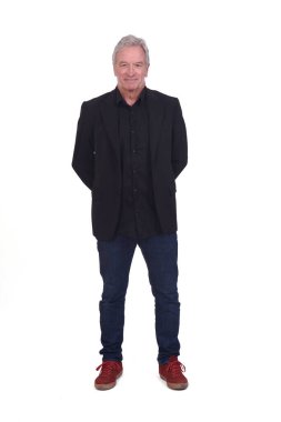 Spor ayakkabı ve spor ceket giymiş, elleri arkada beyaz arka planda olan bir adamın ön görüntüsü.