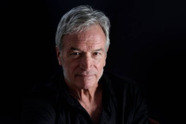 Siyah arka planda üst düzey bir adamın ön görünüm portresi