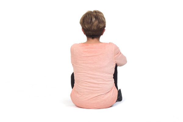 rear view of a senior woman sitting on the floor  on white background