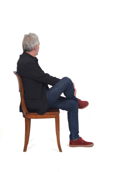 Side View Man Sitting Chair Sneakers Jeans Blazer Looking Background — 스톡 사진