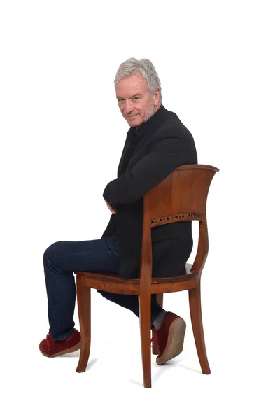 Turnig Man Sitting Chair Sneakers Jeans Blazer White Background — Zdjęcie stockowe