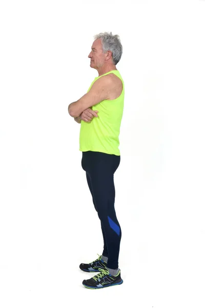 一个身穿运动服紧身衣 头戴荧光黄色无袖背心的男子的侧视图 双臂交叉在白色背景上 — 图库照片