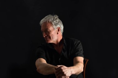 Adam siyah arka plana bakıyor.