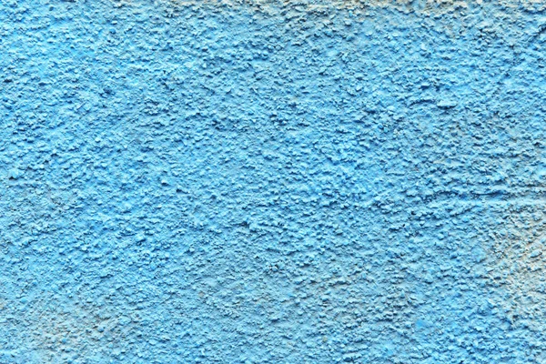 a concrete wall painted with blue spray paint