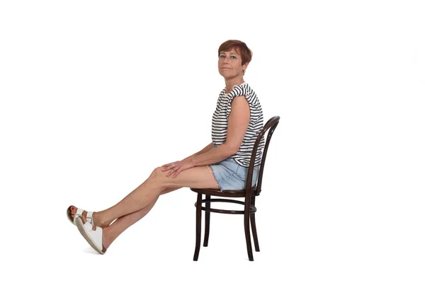 Middle Aged Woman Sitting Chair Stretched Legs White Background — kuvapankkivalokuva