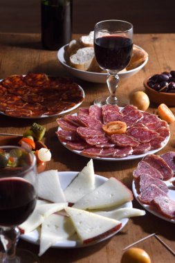 tapas and red wine on wooden table