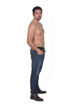 side view of a shirtless man with hands on pockets on white background
