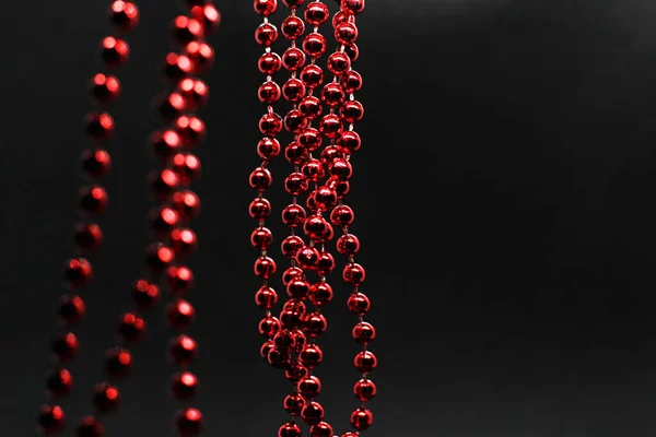 Guirlande de perles de Noël rouge suspendue sur un fond noir — Photo
