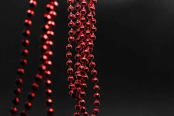 Grinalda de Natal vermelho pendurado em um fundo preto — Fotografia de Stock