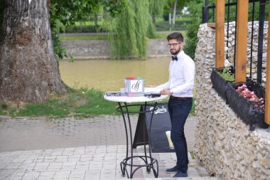 TIMISOARA, ROMANIA - 24 Haziran 2018: Opera Moda Fuarı adı verilen hayır etkinliği. Sahne arkasında resmi giyinmiş beyaz gömlekli bir adamın detayları.