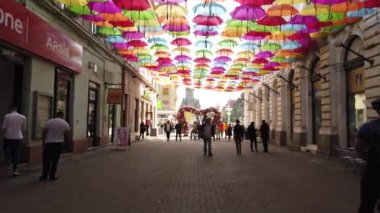 TIMISOARA, ROMANIA - 19 Nisan 2019: TiMFLORALIS Uluslararası Çiçek Festivali 'nde sokakta asılı duran renkli şemsiye. Romanya 'nın Timisoara kentinde halk sokak sanatları festivali düzenliyor. 