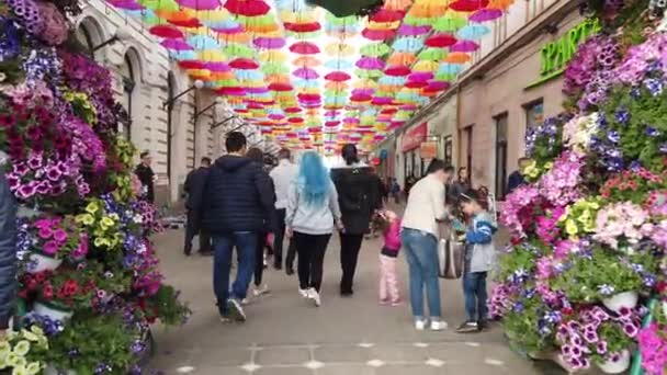 Timisoara Romania 2019年4月19日 ティムフラリス国際フラワーフェスティバルの通りに吊るされたカラーの傘 ルーマニアのティミソアラでストリートアートの花祭りを楽しむ人々 — ストック動画
