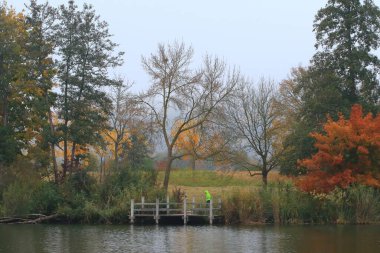 İnsanlar gün batımında Almanya 'nın Regensburg kentindeki Tuna Nehri boyunca kırsal bir yolda koşuyorlar..