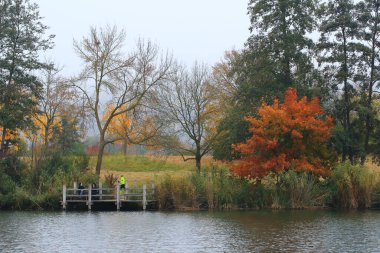 Regensburg, Almanya - 28 Ekim 2021: İnsanlar gün batımında Tuna Nehri boyunca Almanya 'nın Regensburg kentinde Avrupa' da kırsal bir yolda koşuyorlar..