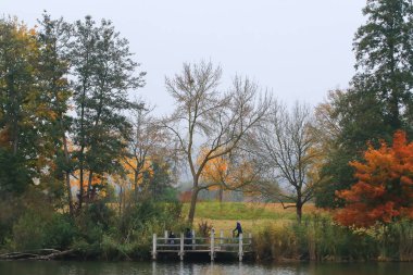 Regensburg, Almanya - 28 Ekim 2021: İnsanlar gün batımında Tuna Nehri boyunca Almanya 'nın Regensburg kentinde Avrupa' da kırsal bir yolda koşuyorlar..