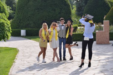 TIMISOARA, ROMANIA - 4 Mayıs 2018: Üniversite mezunu öğrenciler parkta fotoğraf çekimi yapıyorlar