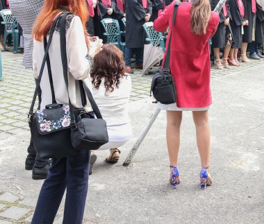 Üniversite mezunu öğrenciler parkta fotoğraf çekimi yapıyorlar.