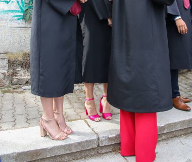 Üniversite mezunu öğrenciler parkta fotoğraf çekimi yapıyorlar.