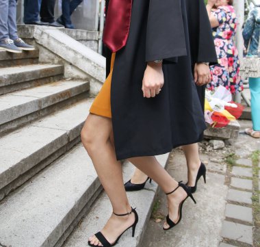 Üniversite mezunu öğrenciler parkta fotoğraf çekimi yapıyorlar.