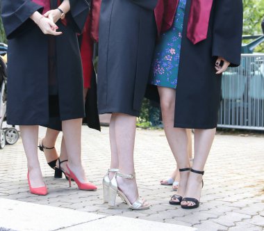 Üniversite mezunu öğrenciler parkta fotoğraf çekimi yapıyorlar.