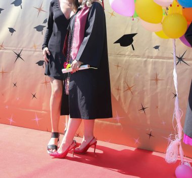 Üniversite mezunu öğrenciler parkta fotoğraf çekimi yapıyorlar.