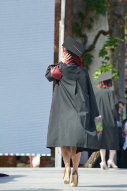 Üniversite mezunu öğrenciler parkta fotoğraf çekimi yapıyorlar.