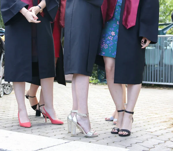 Üniversite mezunu öğrenciler parkta fotoğraf çekimi yapıyorlar.