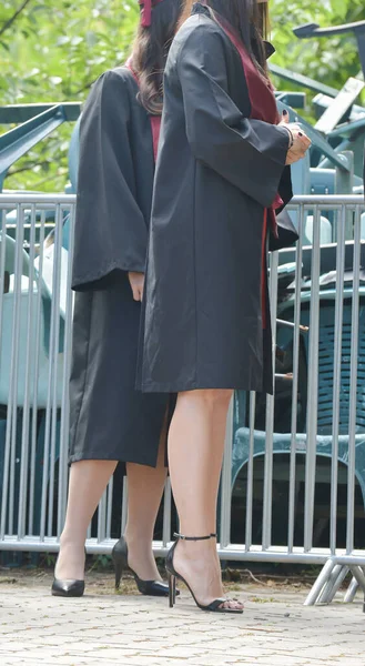 Üniversite mezunu öğrenciler parkta fotoğraf çekimi yapıyorlar.