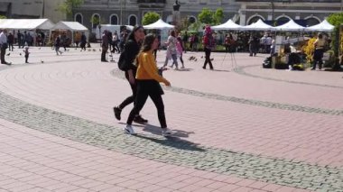 TIMISOARA, ROMANIA - 19 Nisan 2019: TIMFLORALIS Uluslararası Çiçek Festivali. İnsanlar ve turistler şehir merkezindeki çiçek süslemelerinin tadını çıkarıyorlar. Yavaş çekim görüntüleri