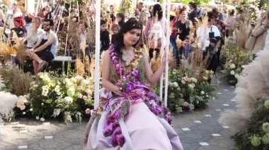 TIMISOARA, ROMANIA - 19 Nisan 2019: Zafer Meydanı, TIMFLORALIS Uluslararası Çiçek Festivali. Çiçekli bir elbise giyen festivalin kraliçesi sokakta yürüyor. Yavaş çekim görüntüleri