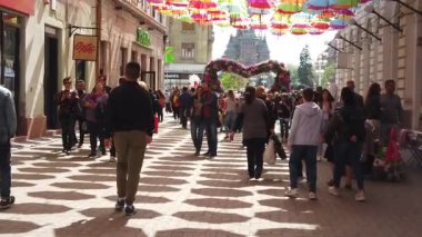 TIMISOARA, ROMANIA - 19 Nisan 2019: Zafer Meydanı, TIMFLORALIS Uluslararası Çiçek Festivali. Farklı etnik kökenden insanlar renkli şemsiyeler altında yürüyorlar. Yavaş çekim görüntüleri