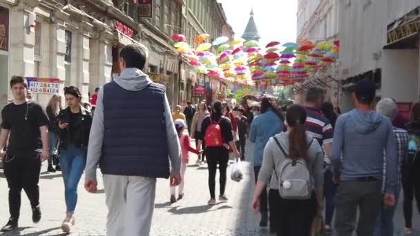 Timisoara Romania 2019年4月19日 Victory Square Timflalis国際フラワーフェスティバル 異なる民族の人々が色の傘の下を歩いている スローモーション映像 — ストック動画