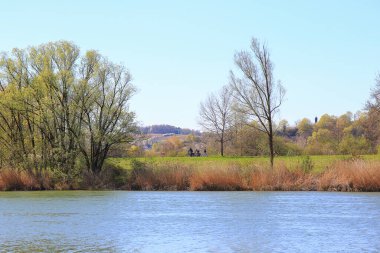 Regensburg, Almanya: İnsanlar gün batımında Regensburg, Almanya ve Avrupa 'da Tuna Nehri boyunca kırsal bir yolda bisiklete biniyorlar.