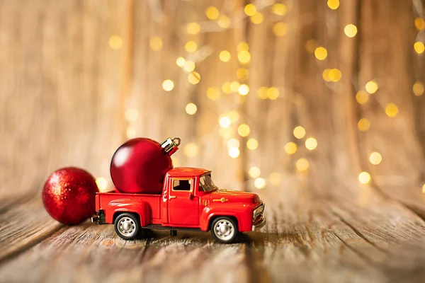 Carro em miniatura no fundo de madeira com luz de Natal. — Fotografia de Stock