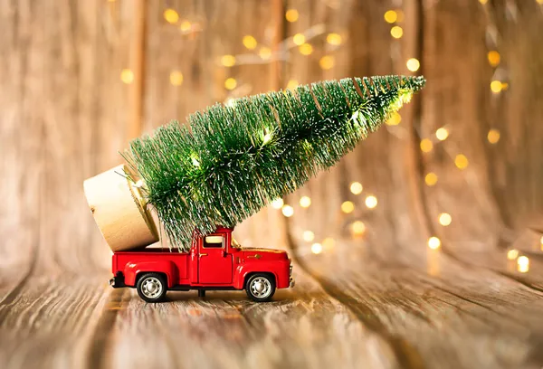 Carro em miniatura no fundo de madeira com luz de Natal, presente de férias. — Fotografia de Stock