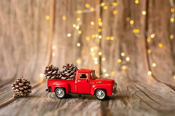 Carro em miniatura no fundo de madeira com luz de Natal. — Fotografia de Stock